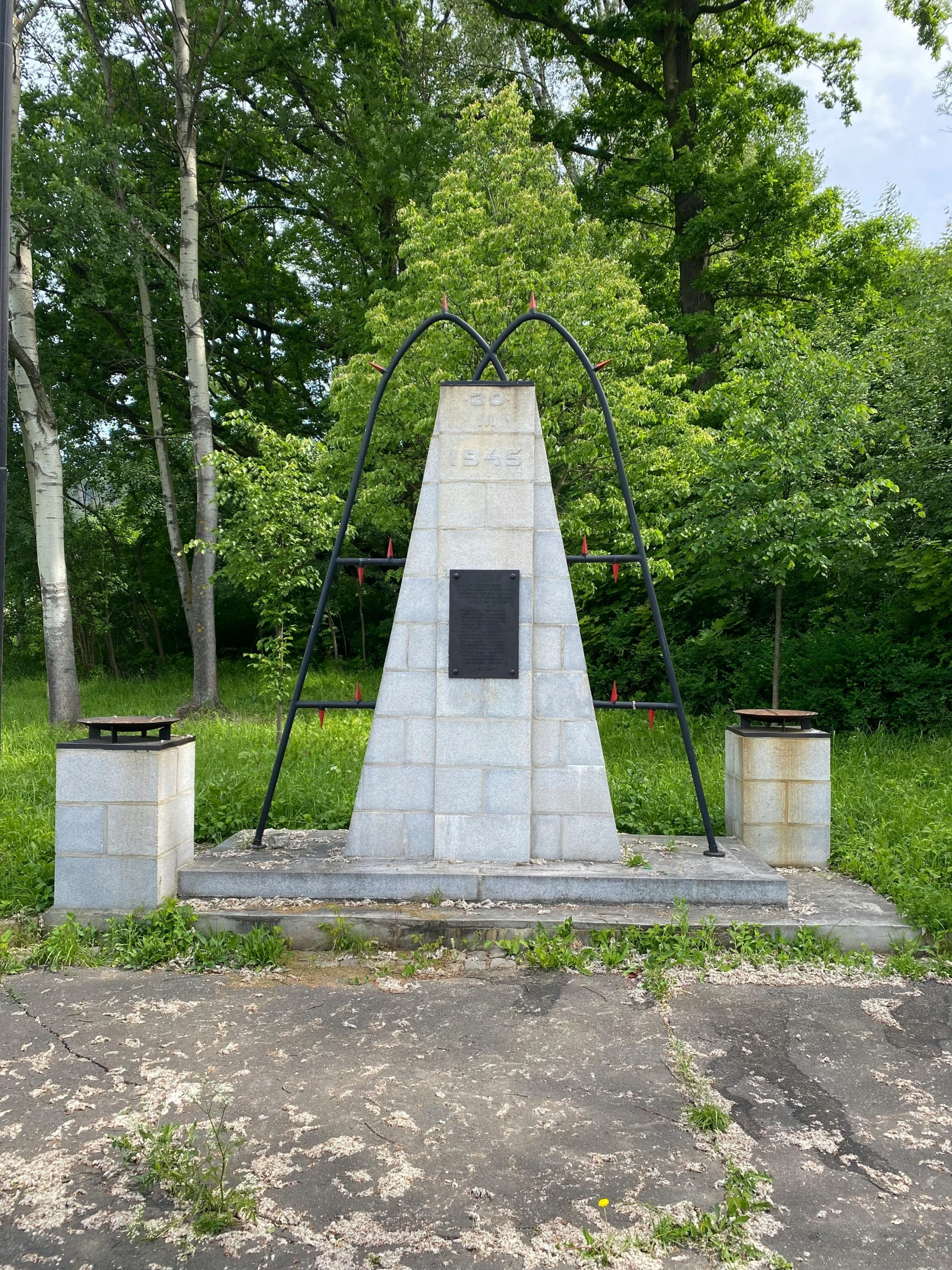 two statues are shown in the park with trees