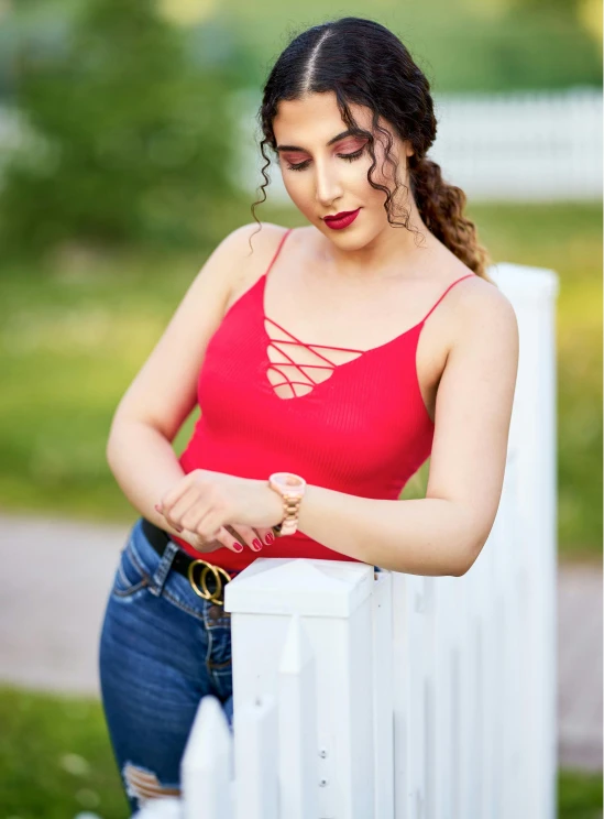 woman leaning on fence outside with arms crossed