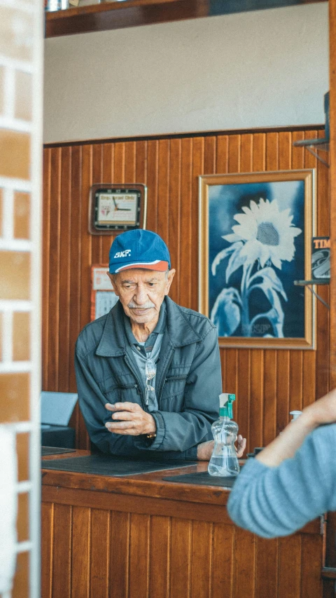 an elderly gentleman sitting in a el reception booth