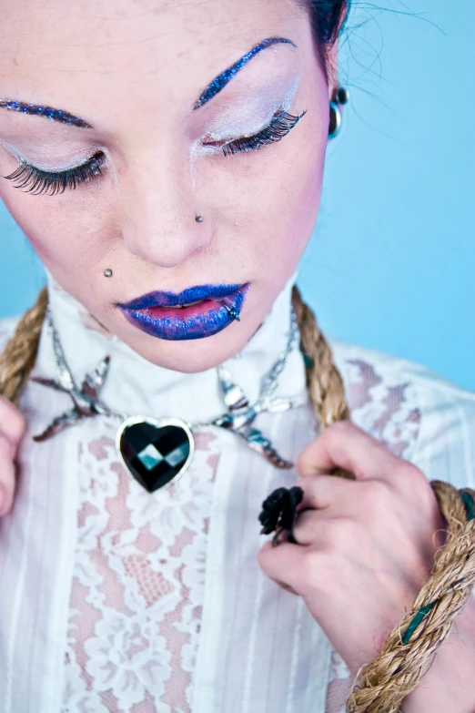 a young woman has blue makeup and some rope around her