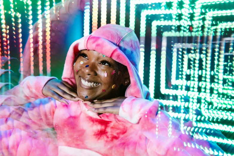 a woman with a hood and face covered in colored powder