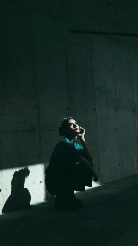 a woman sits on the floor, casting a shadow