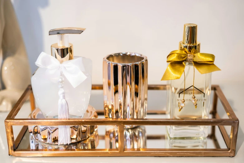 a golden tray with various perfume bottles in it