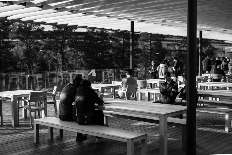 people are sitting outside with many tables