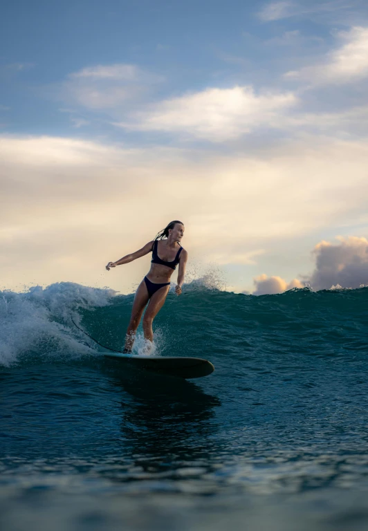 a young woman in a bathing suit surfing on the water