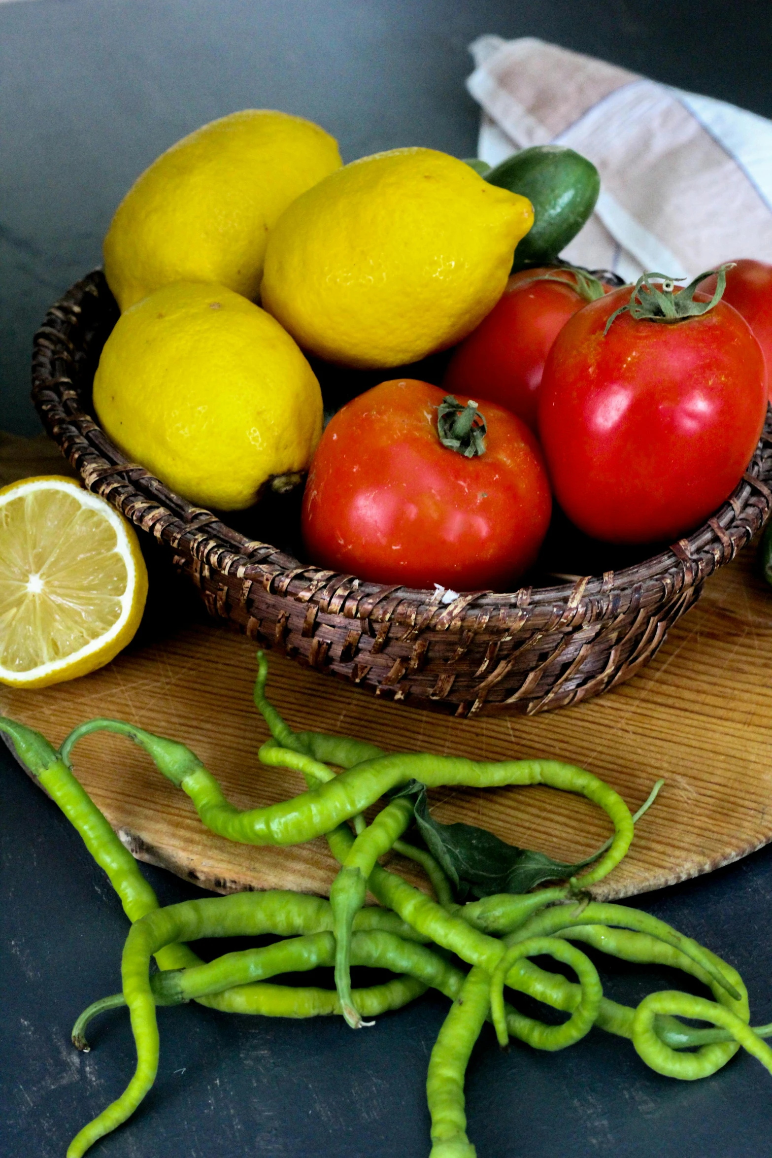 a bowl full of tomatoes, lemons and peppers