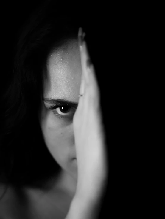 black and white image of a woman holding her face
