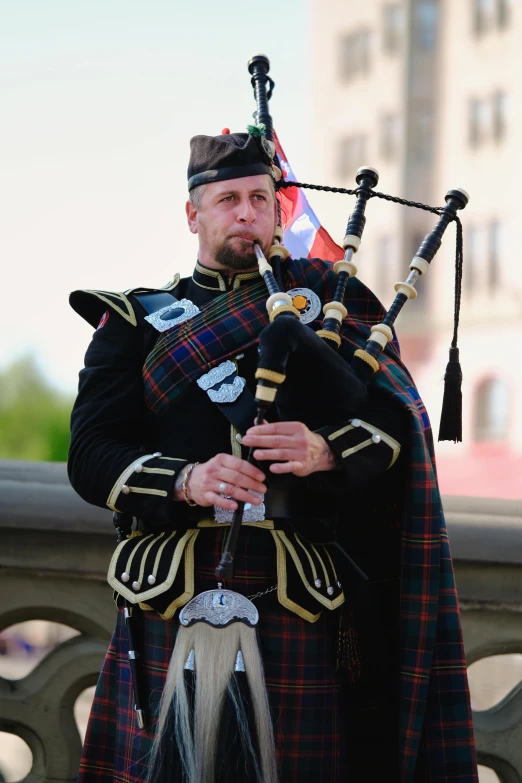 a man in a kilt playing bagpipes and drums