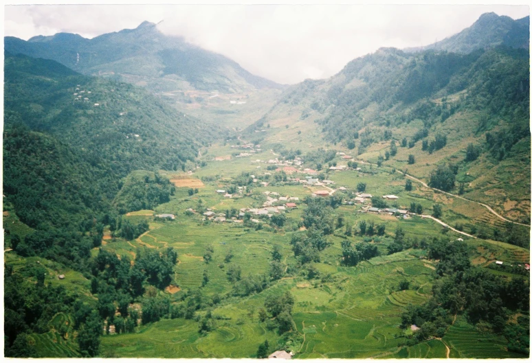 the view from above of a village nestled in the middle of some mountains