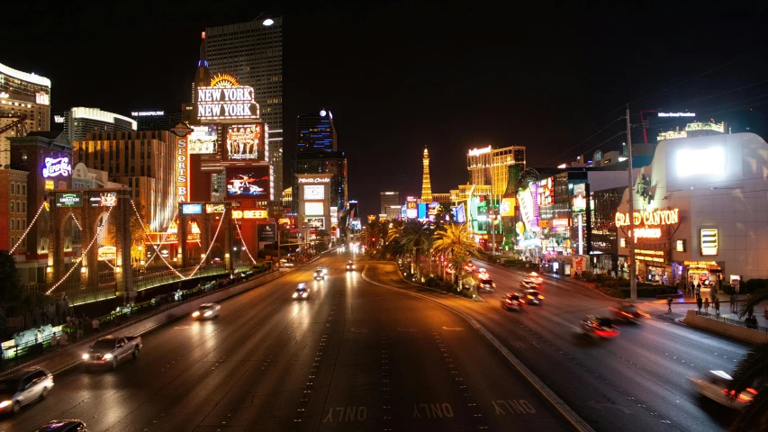 a busy street at night with several cars driving on it