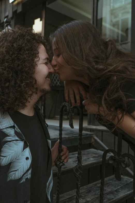 a beautiful young lady kissing a man on the cheek