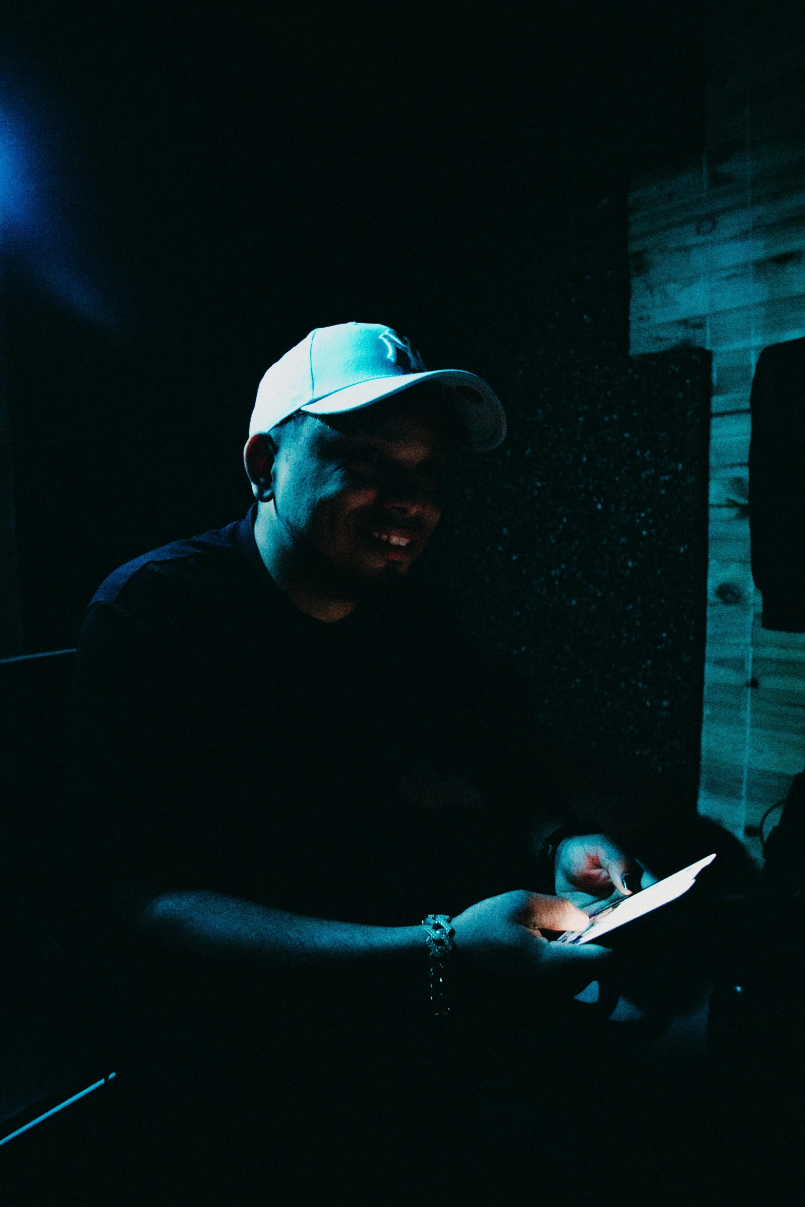 man in a dark room holding a lit device