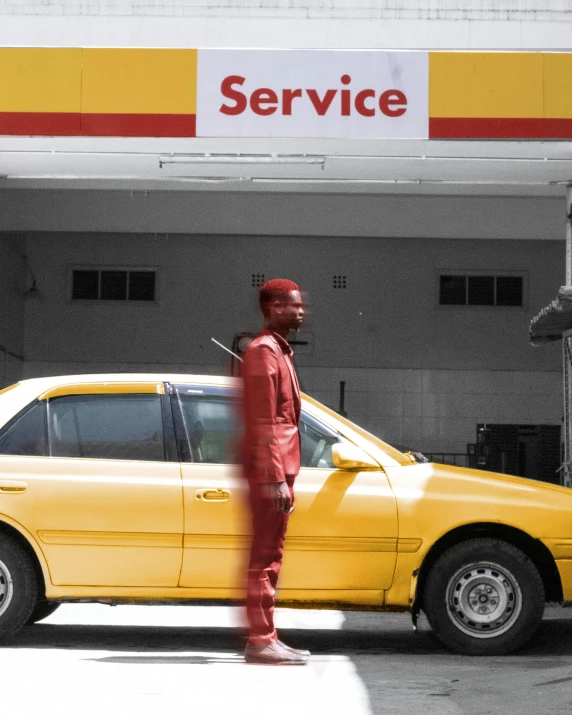 a man stands in front of a yellow car