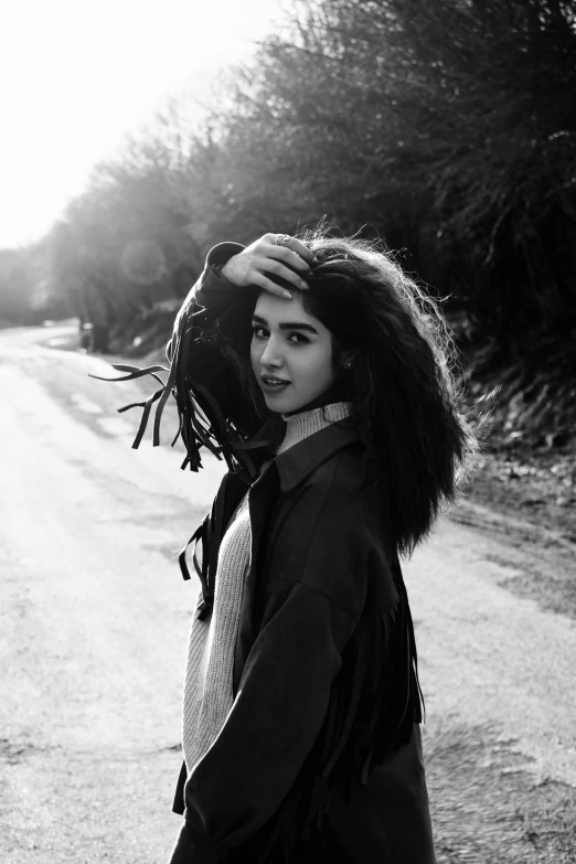 young woman with her hair in a large scarf walking down the street