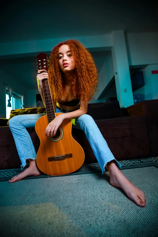 a woman sitting on the floor with a guitar