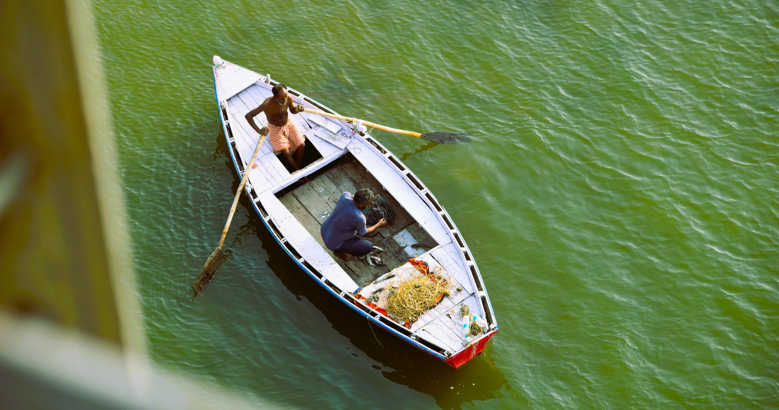 a man sits in the center of his small boat