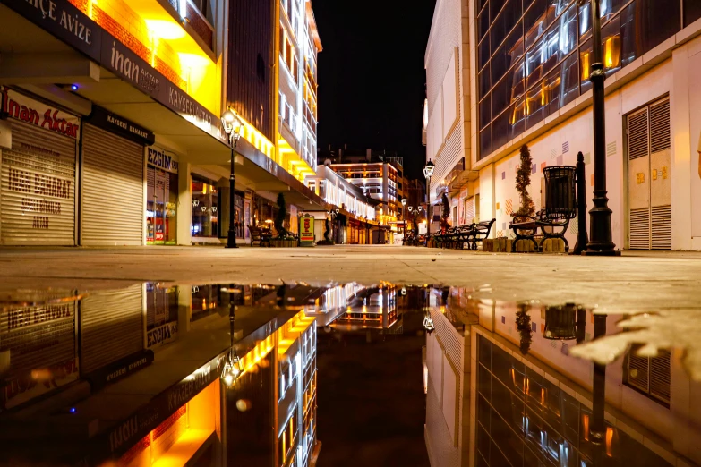 buildings reflect in the wet ground in this po