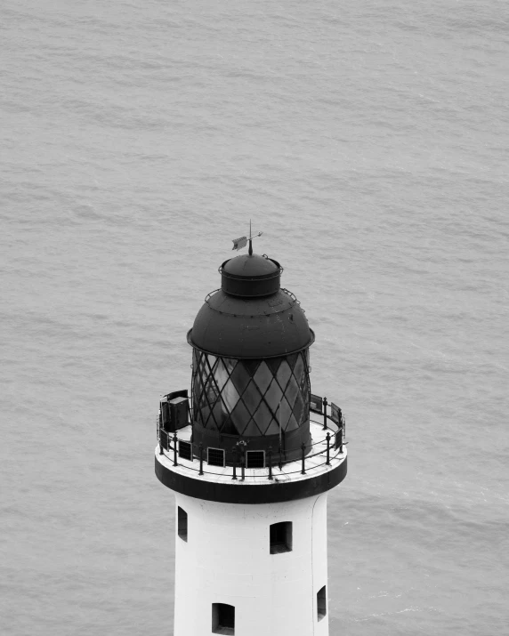 a lighthouse on a black and white po of the ocean