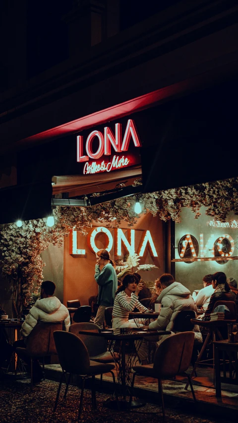 a group of people sitting at tables in front of a store