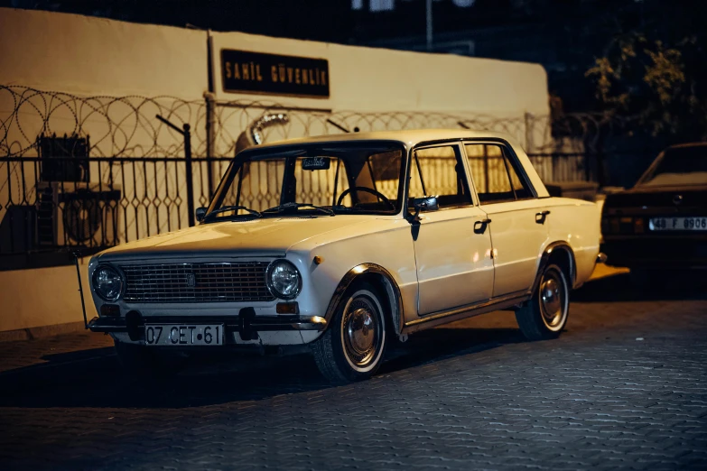 a car parked in front of a building with a fence