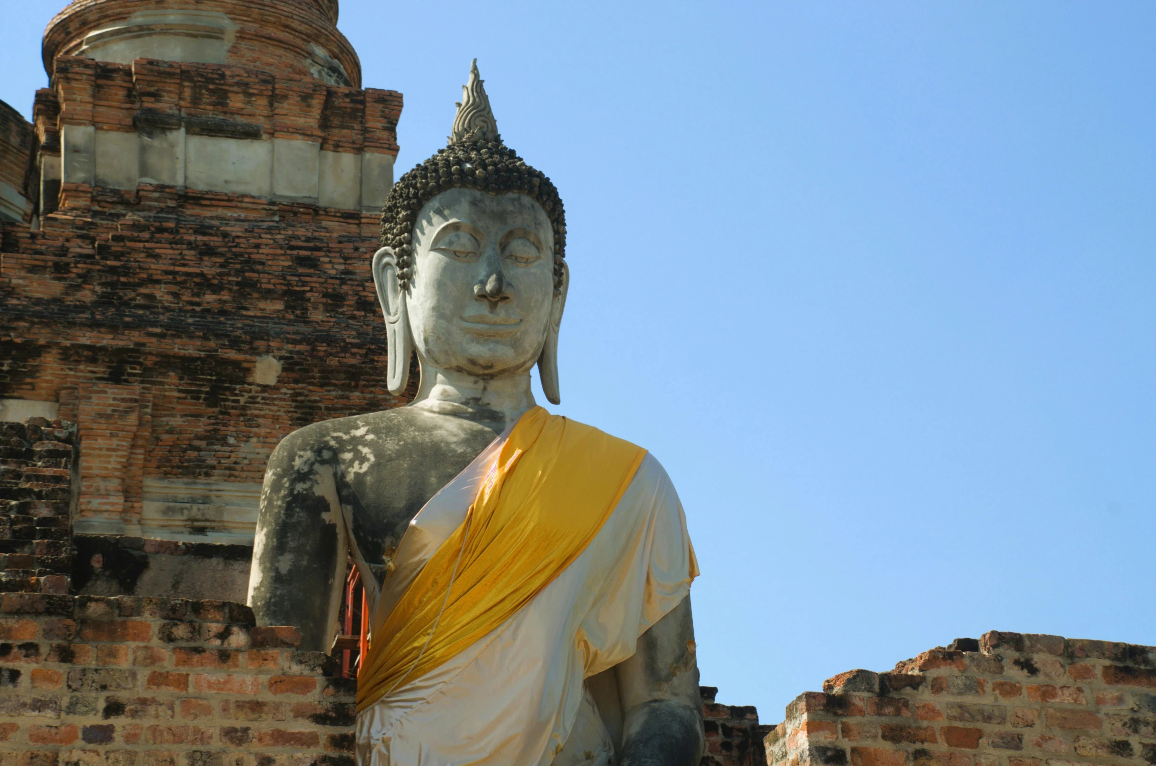 the statue is wearing an orange shawl with a black head