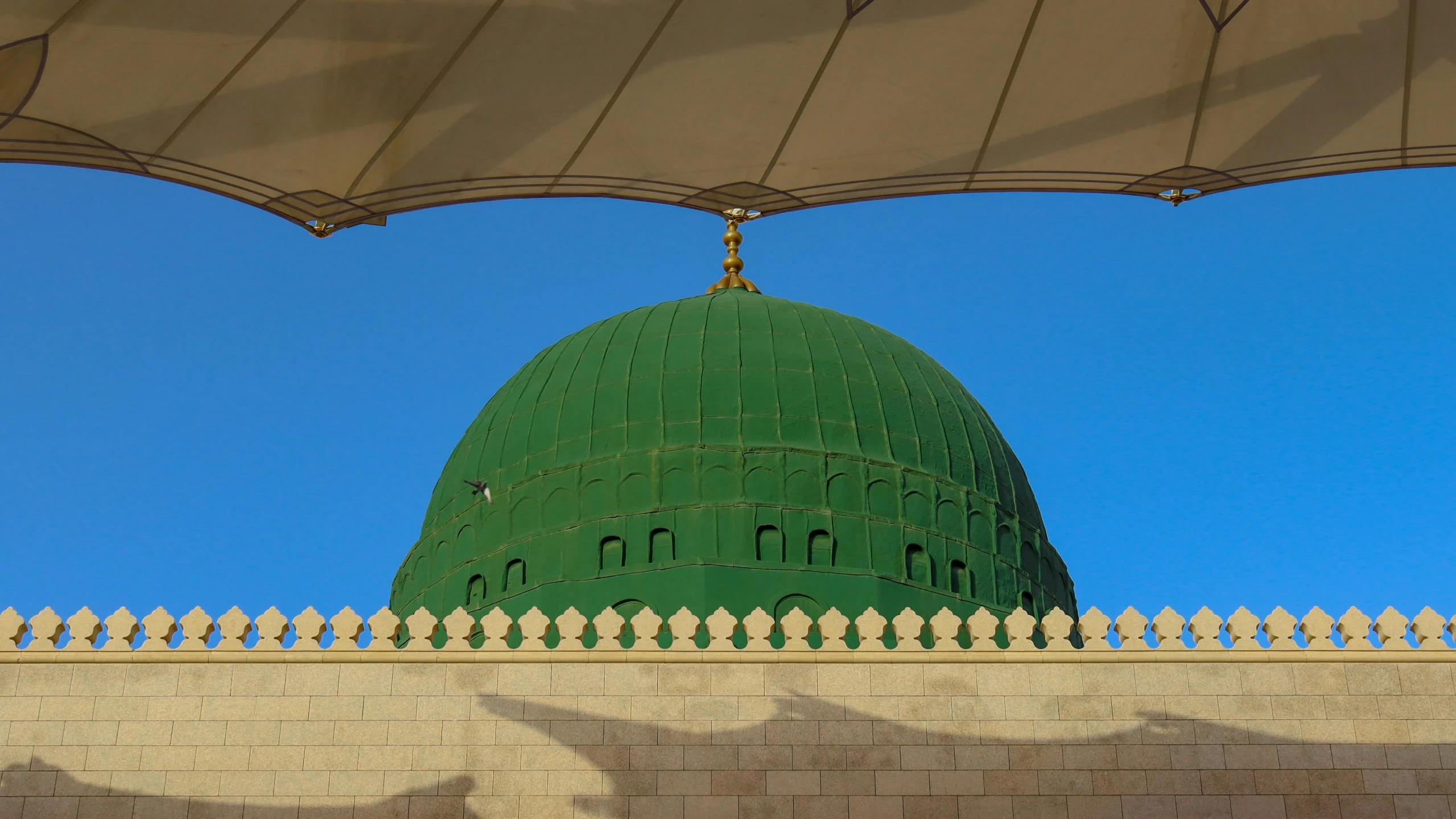 a building under a clear blue sky that is green