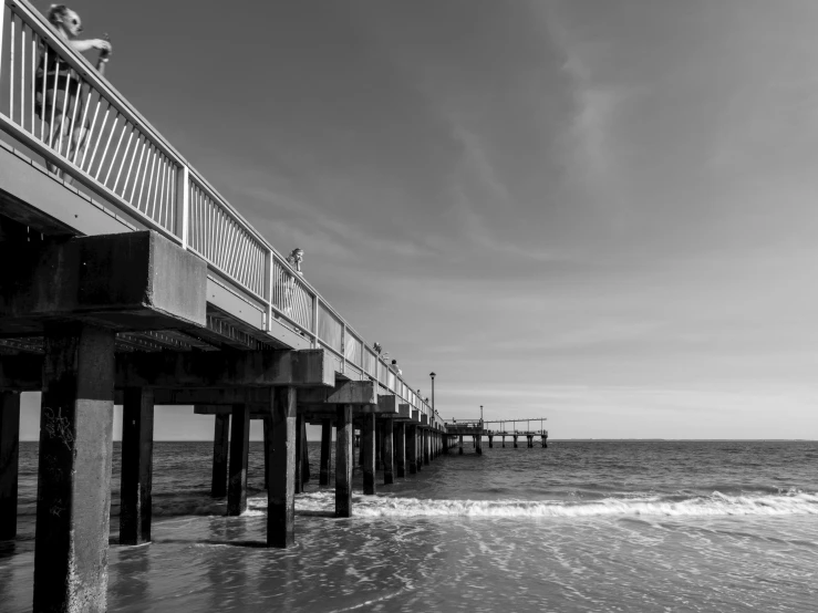 black and white picture of pier by the beach