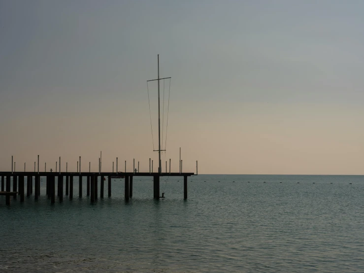 a sailboat on the water near a pier