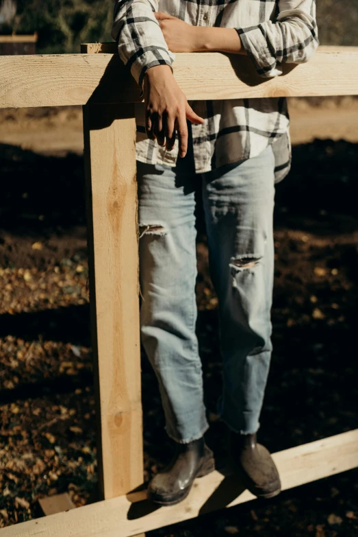 a man with his hands on a wooden pole