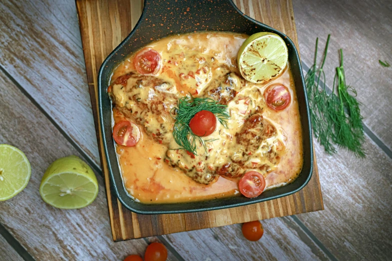 chicken, tomatoes, and lime on a wooden  board