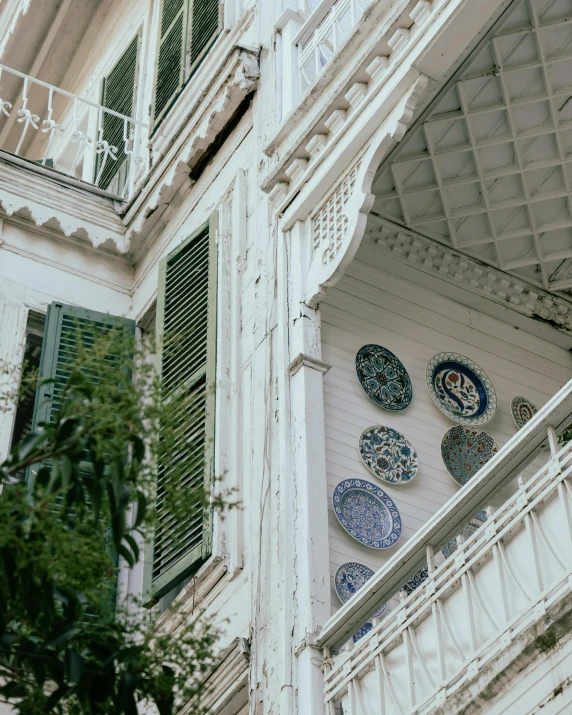 blue and white plates on a wall near a balcony