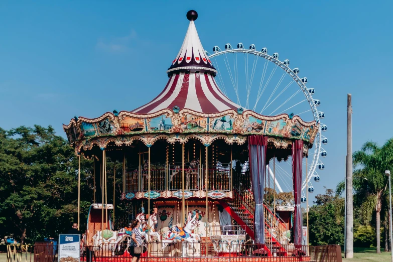 an amut carousel near a park with people standing on the ground