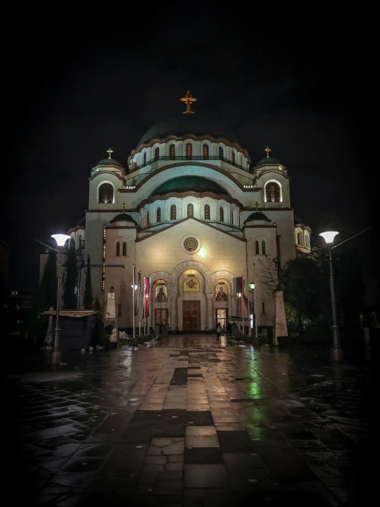 a lit church in the evening, with the dark sky in the background