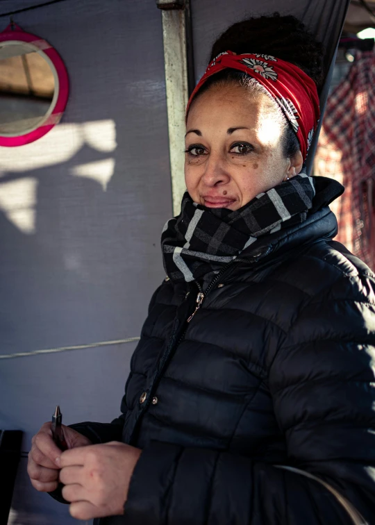 a woman stands outside and smiles with her hands on her hips