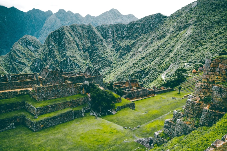 a large structure with lush green lawn near a mountain