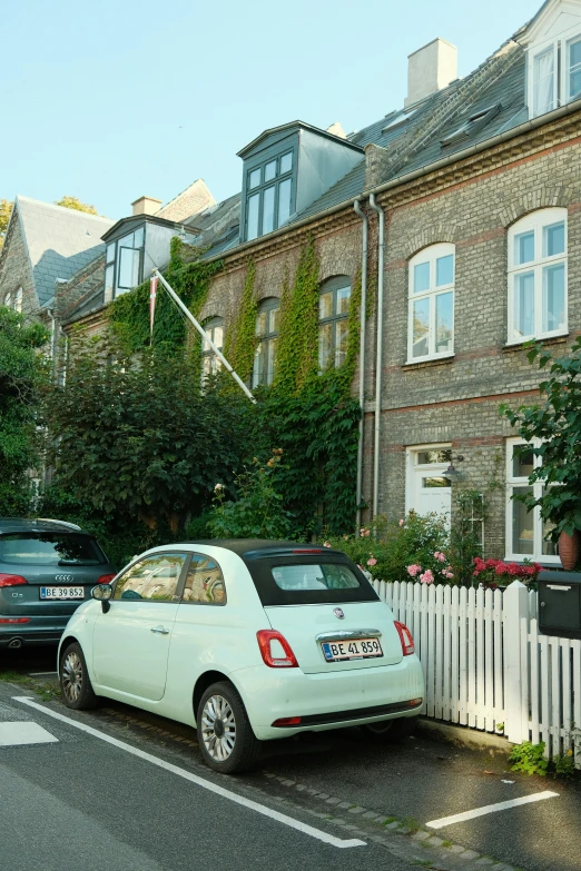 there is a light blue car parked in front of a house