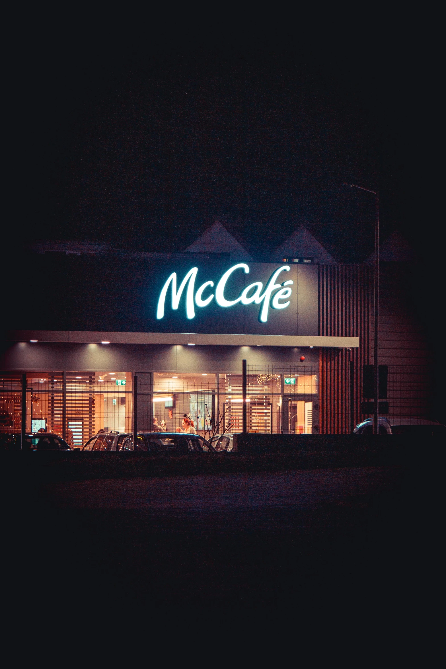 a mcdonald's in a dark building with it's lit sign at night