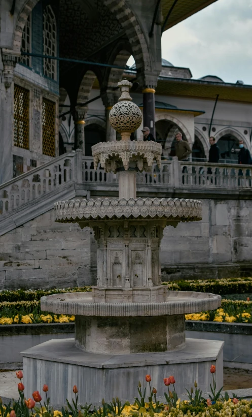 an outdoor fountain in a garden in front of a building