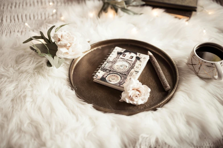 an old style book and cup on a plate