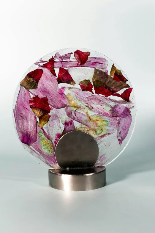 pink flowers are inside of a round glass bowl