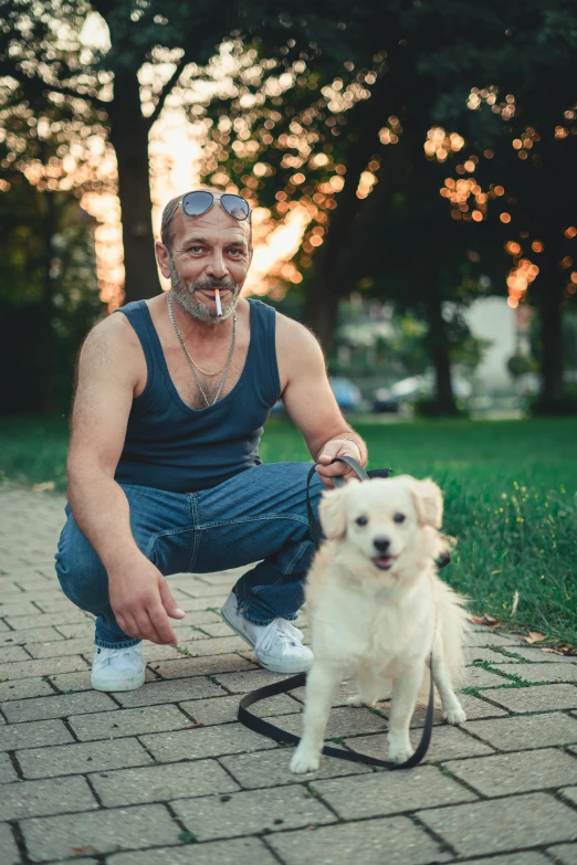 a man sitting on brick path with a dog