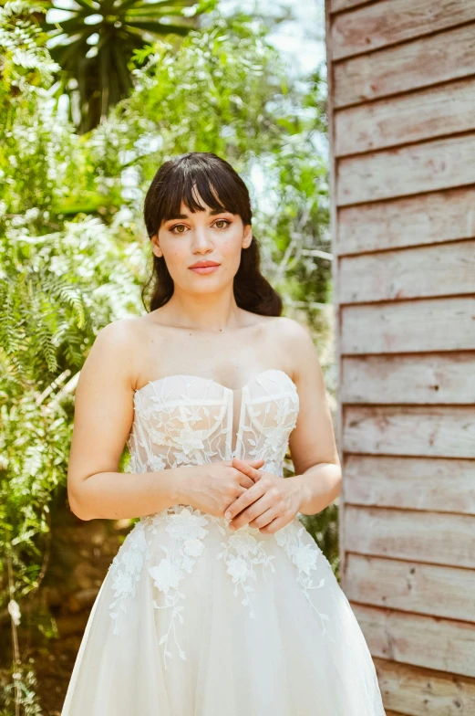 a girl posing for a pograph while wearing a dress