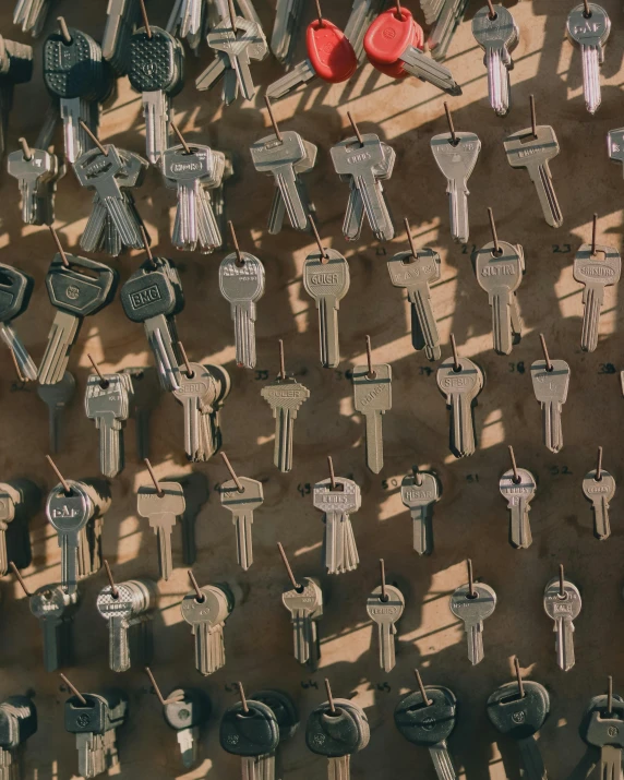 many keys hung on wooden hooks are arranged in a diagonal formation