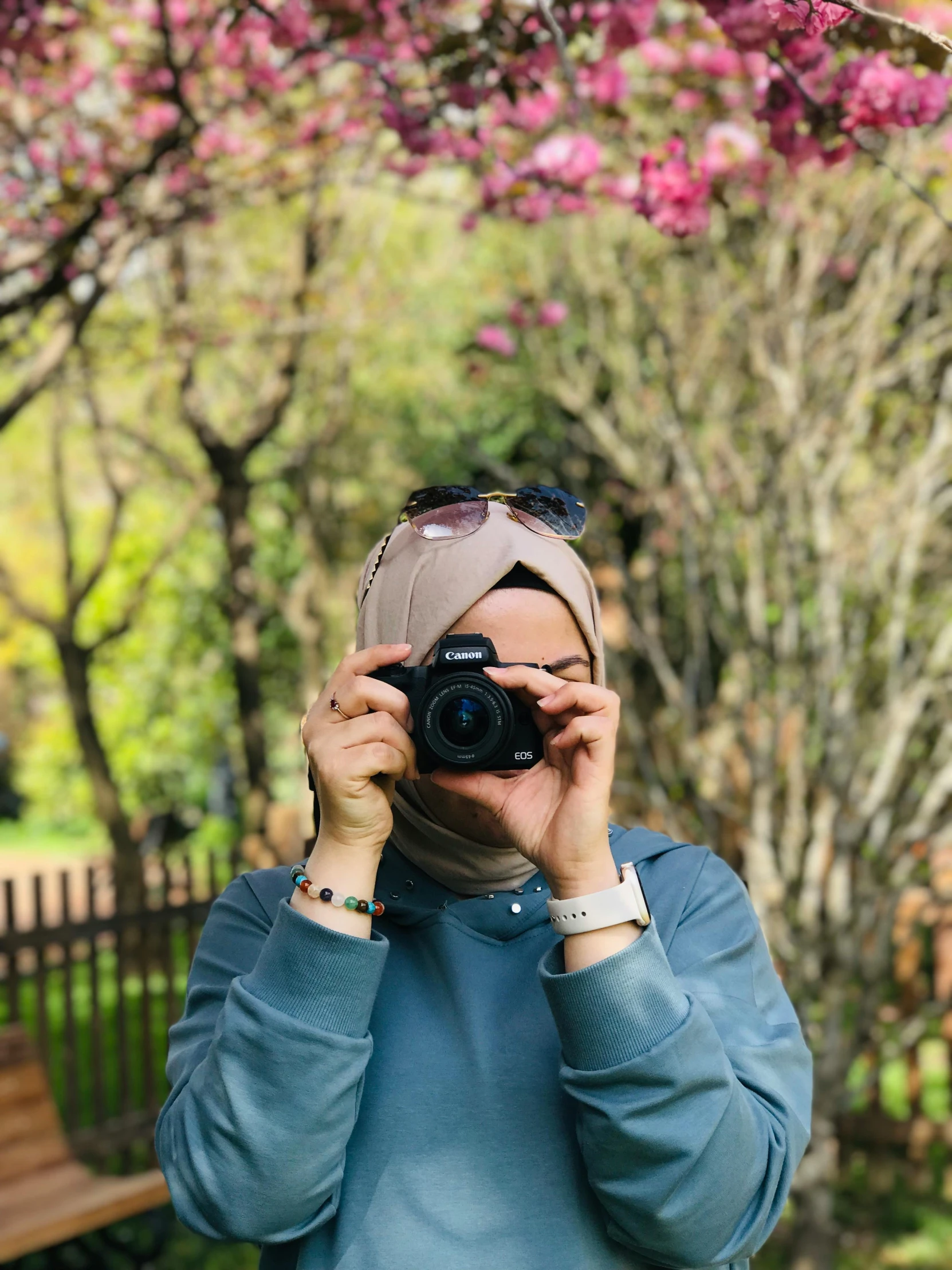 a woman holding a camera up to her face