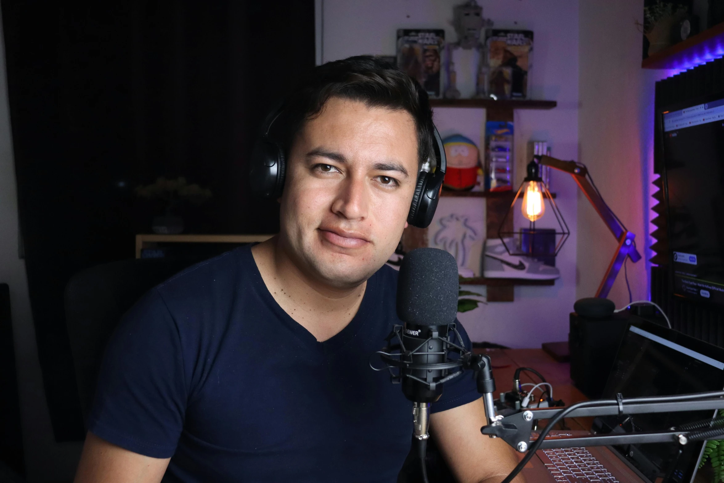 a man sitting in front of a microphone wearing headphones