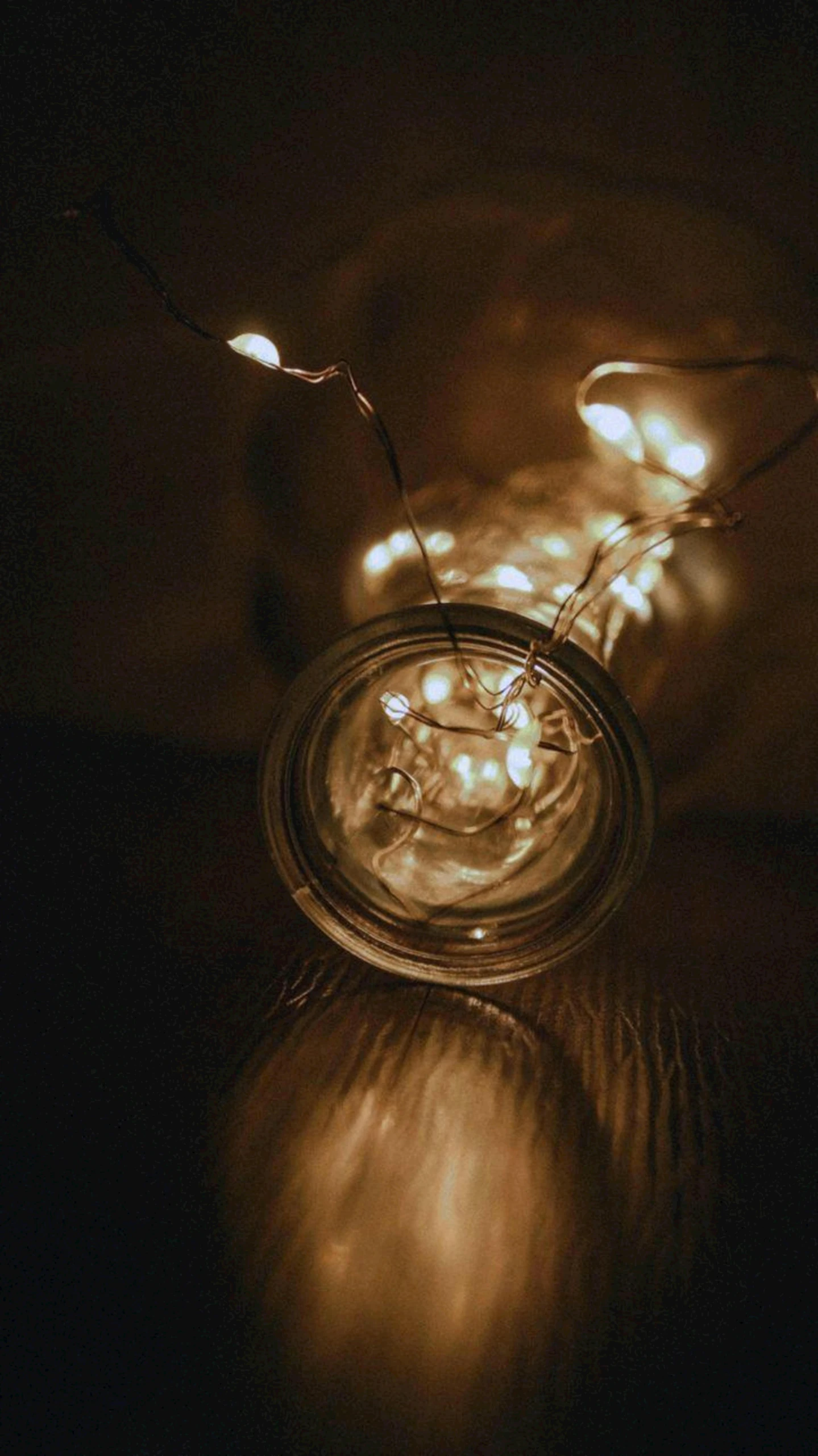 a clear glass on the ground filled with lights