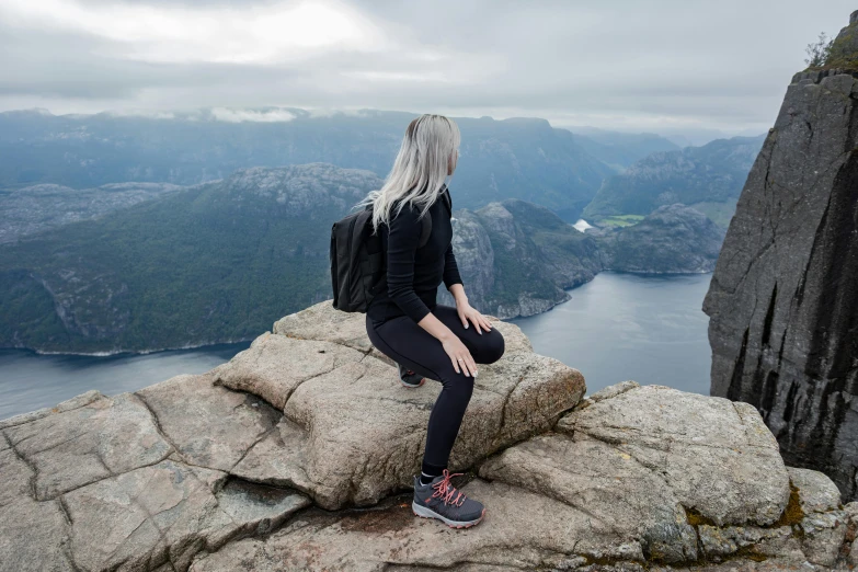 woman on rock with backpack admiring the valley