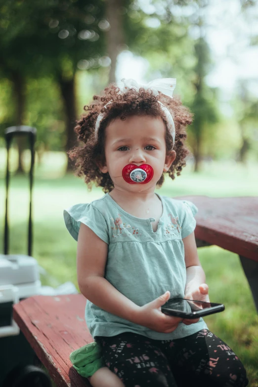 a toddler sitting on top of a red wooden bench