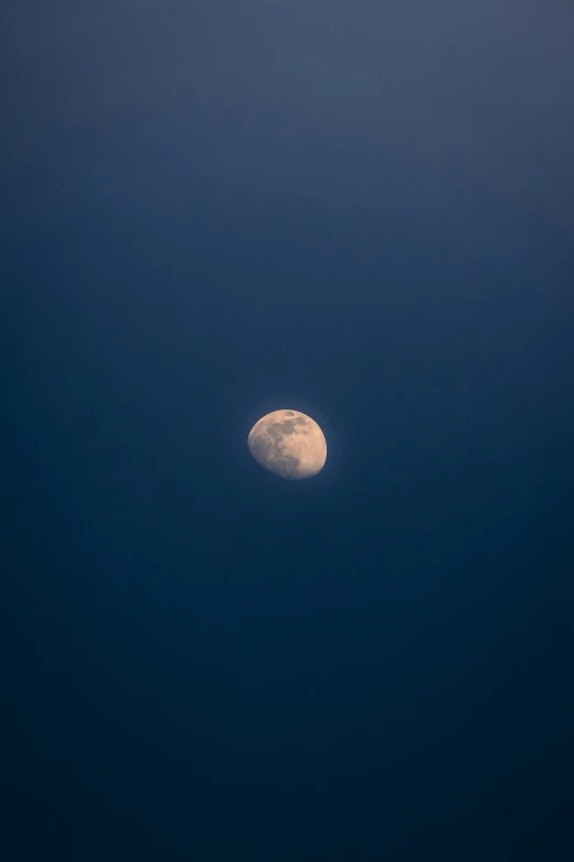 a moon in the blue sky above