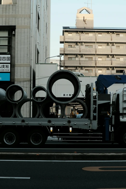 a truck driving on a street past tall buildings